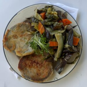Milanesa de berenjenas con salsa de espinaca con de verduras grilladas